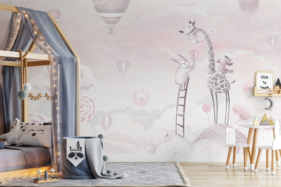 Adorable pink cartoon wall mural in kids room with giraffes and balloons.