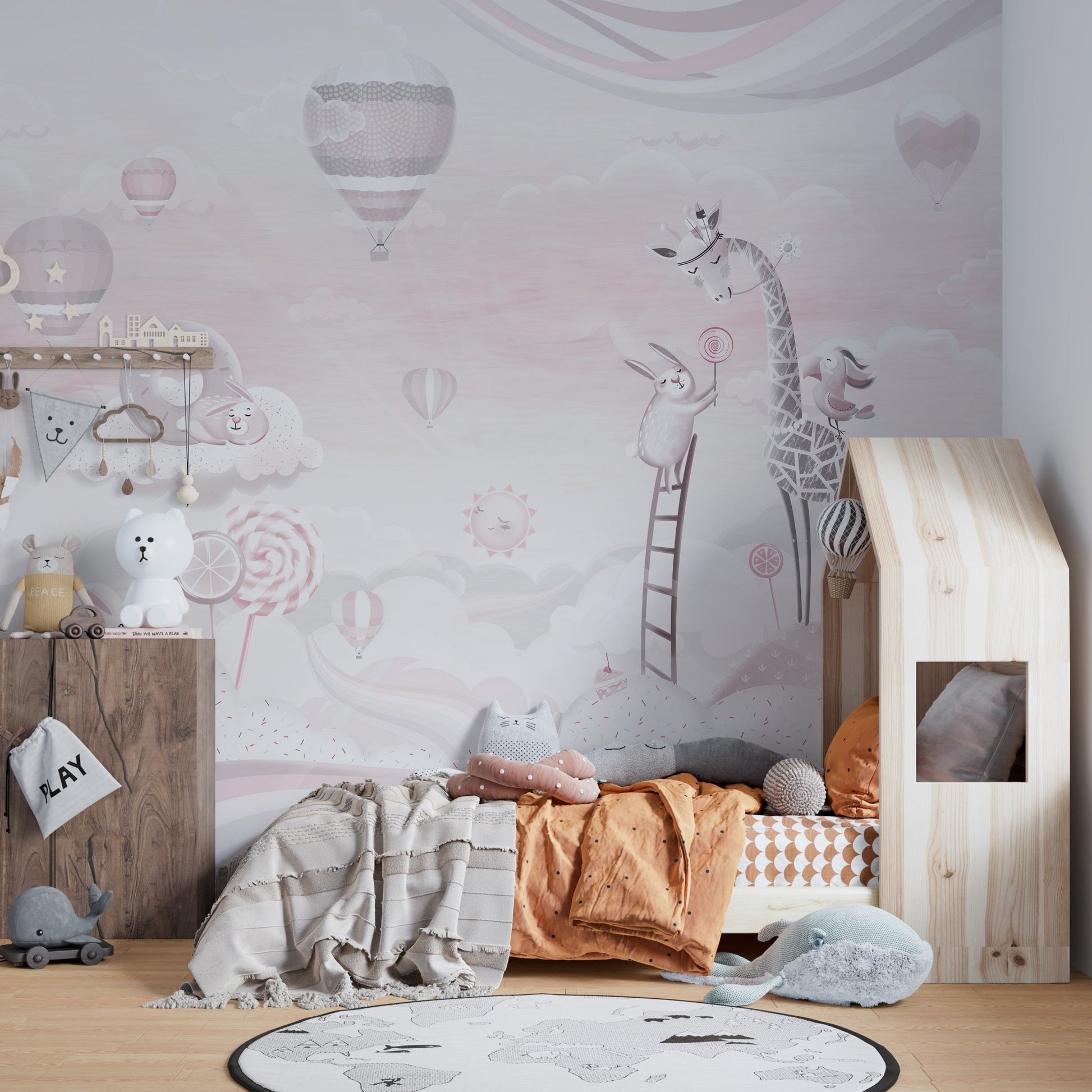 Toddler bed next to an adorable pink cartoon wall mural .