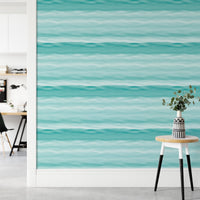 Teal blue wavy stripe wallpaper in a home office with wooden desk