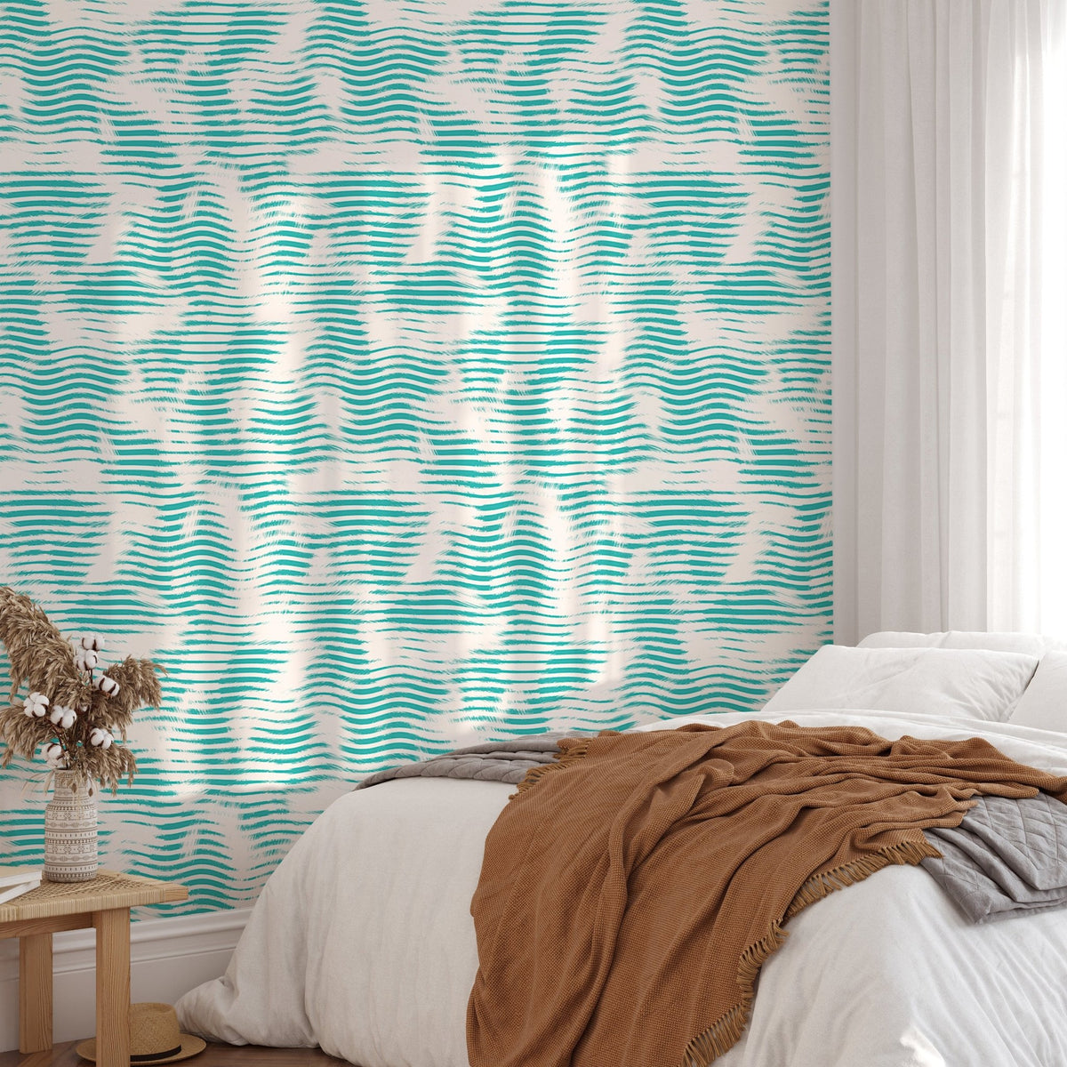 Grunge wave wallpaper in teal for a bedroom with white bedding and a brown throw.