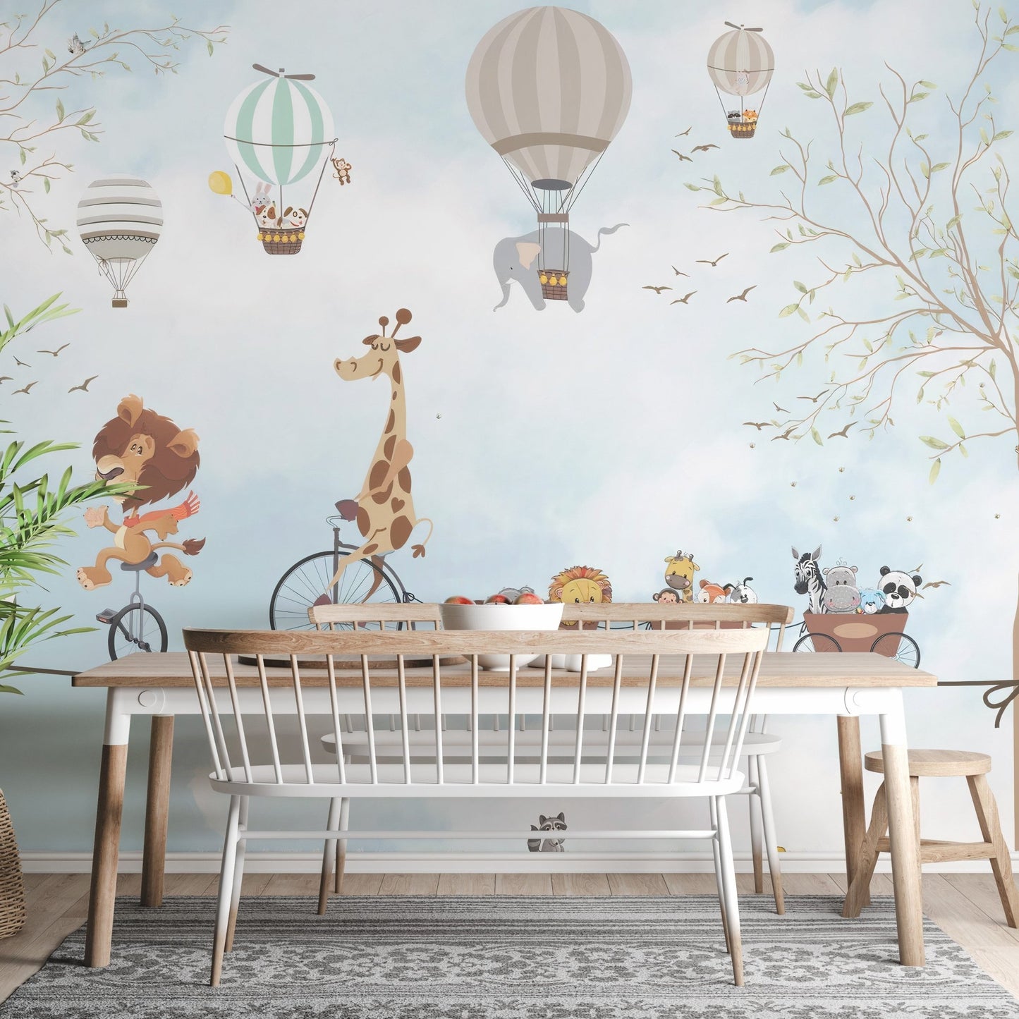Animals in hot air balloons wall mural behind a wooden dining table and chairs.