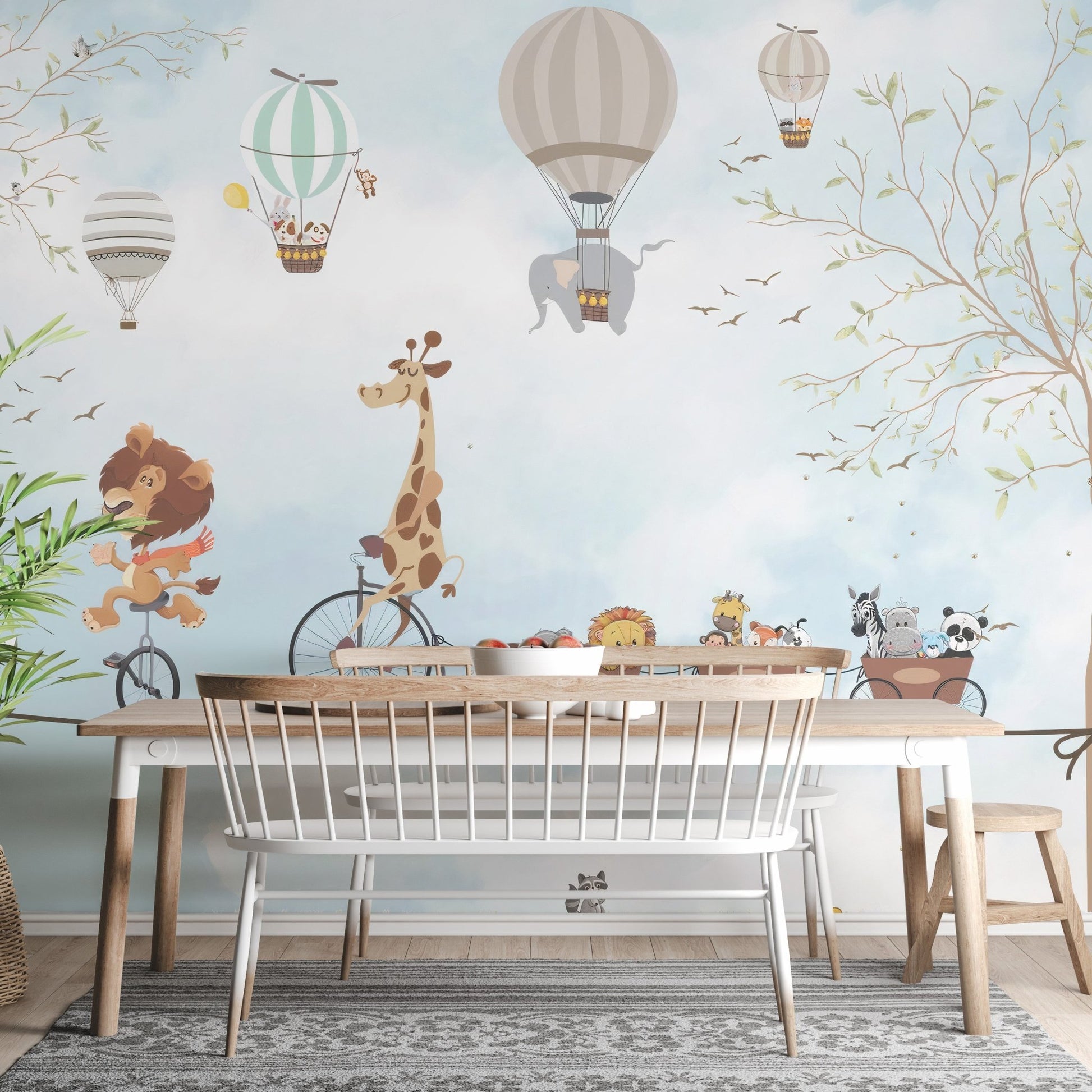 Animals in hot air balloons wall mural behind a wooden dining table and chairs.