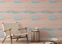Light peach and teal boho wallpaper in a reading area with a wooden armchair.
