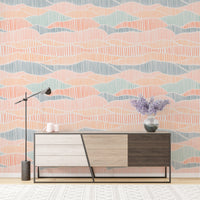 Modern boho wallpaper with pink and blue waves behind a minimalist wooden credenza.