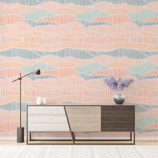 Modern boho wallpaper with pink and blue waves behind a minimalist wooden credenza.