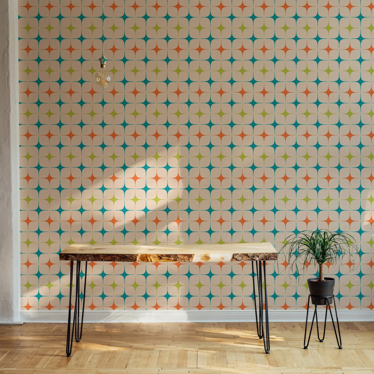 Home office setup with a wooden desk against a star pattern wall mural.