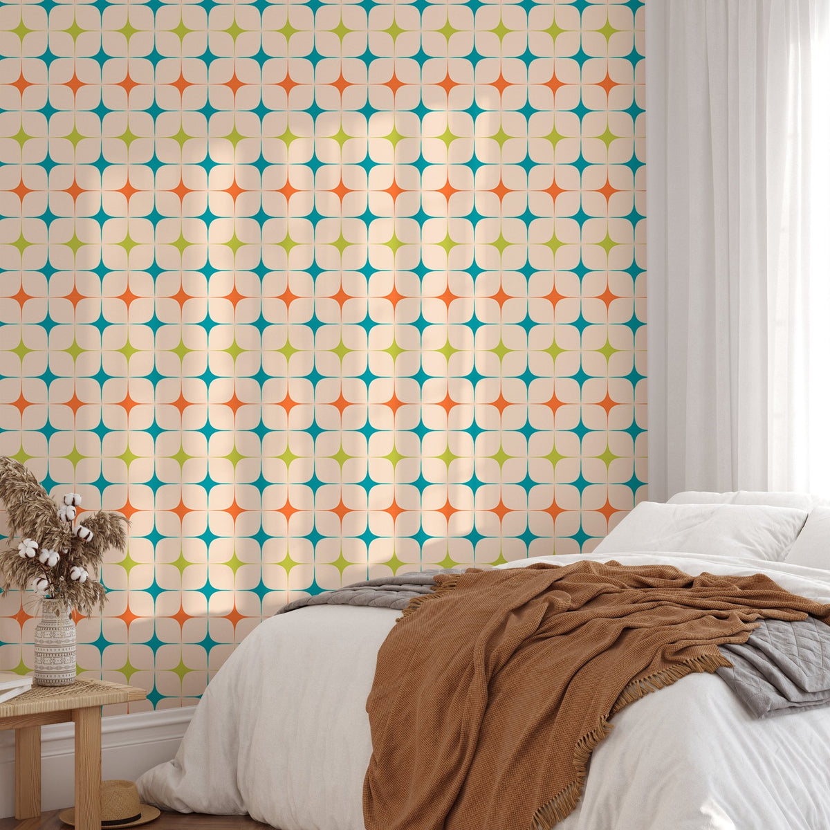 Sunlit bedroom featuring a repeating star pattern wall mural and white linen.