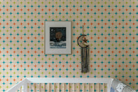 Geometric star pattern wall mural in a nursery with a white cot and framed art.