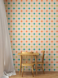 Minimalist kids play area featuring a multicolored star wall mural and wooden chair.