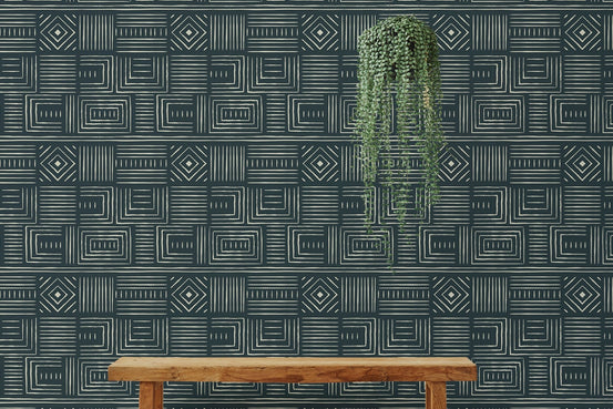Living room wallpaper with tribal patterns behind a wooden bench and hanging plant.