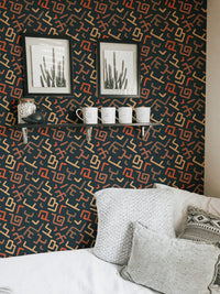 Living room wall with patterned wallpaper behind white sofa.