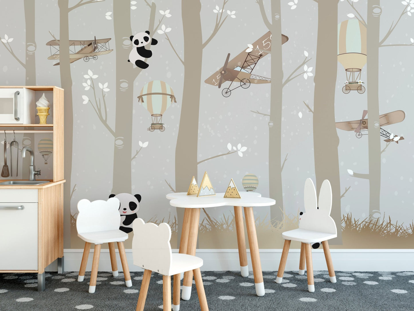 Panda themed wall mural in a toddler room with a small wooden table and chairs.