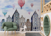 Kids playroom wall mural showing watercolor buildings and a green armchair.