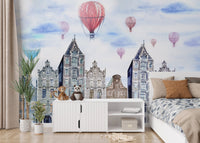 Cityscape wall mural featuring blue gabled houses and red hot air balloons in a bedroom.
