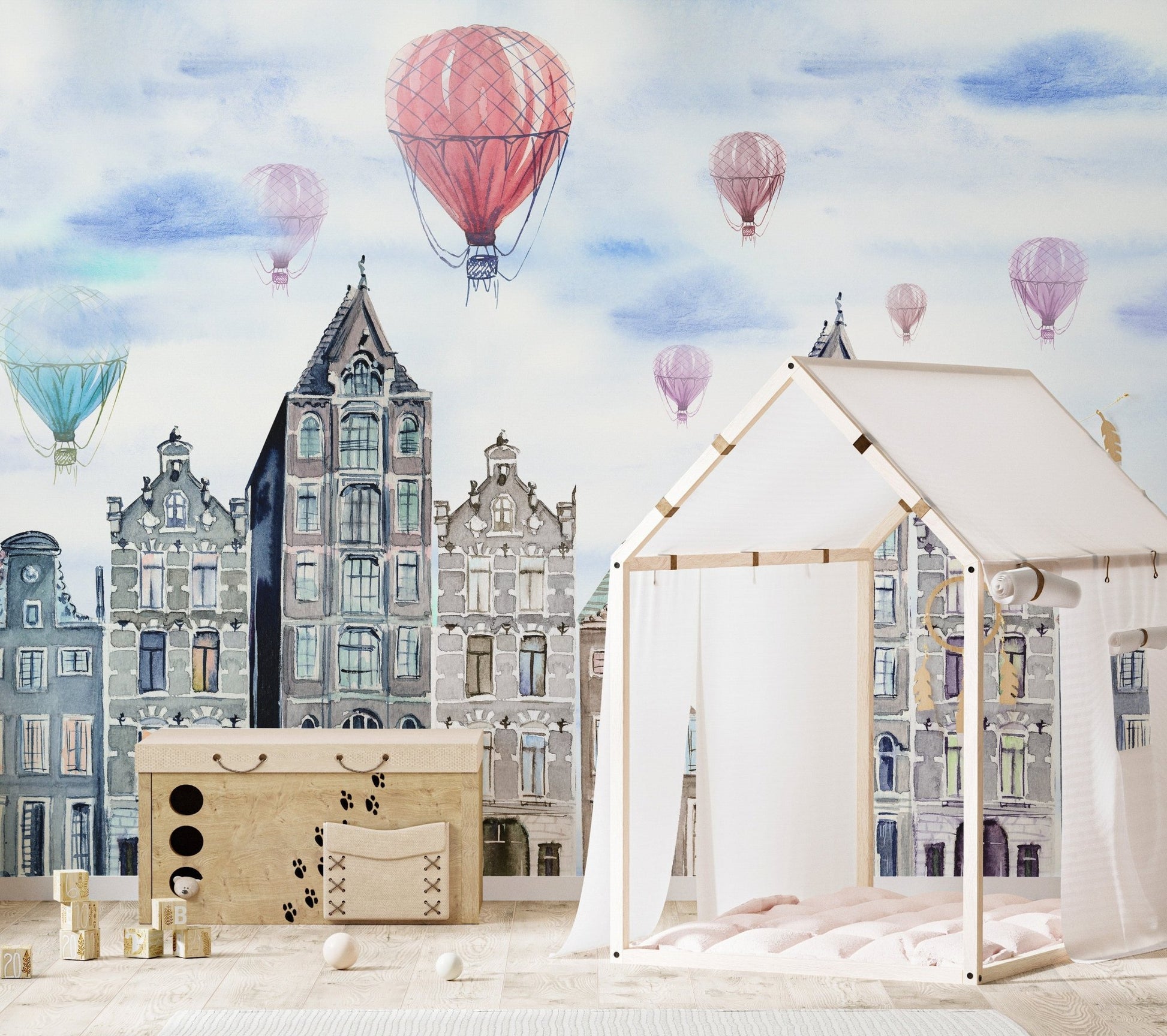 Watercolor city wall mural behind a white house-shaped bed frame in a nursery.