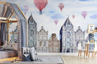 Blue and grey city watercolor wall mural in a child's room with a grey rug and wooden bed.