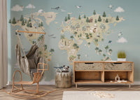 Boho style nursery with a hanging chair and blue map wall mural.