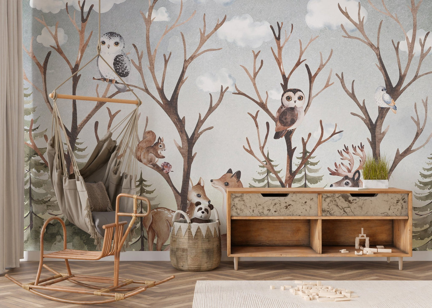 Woodland animal wall mural with owls and trees behind a wooden rocking chair.