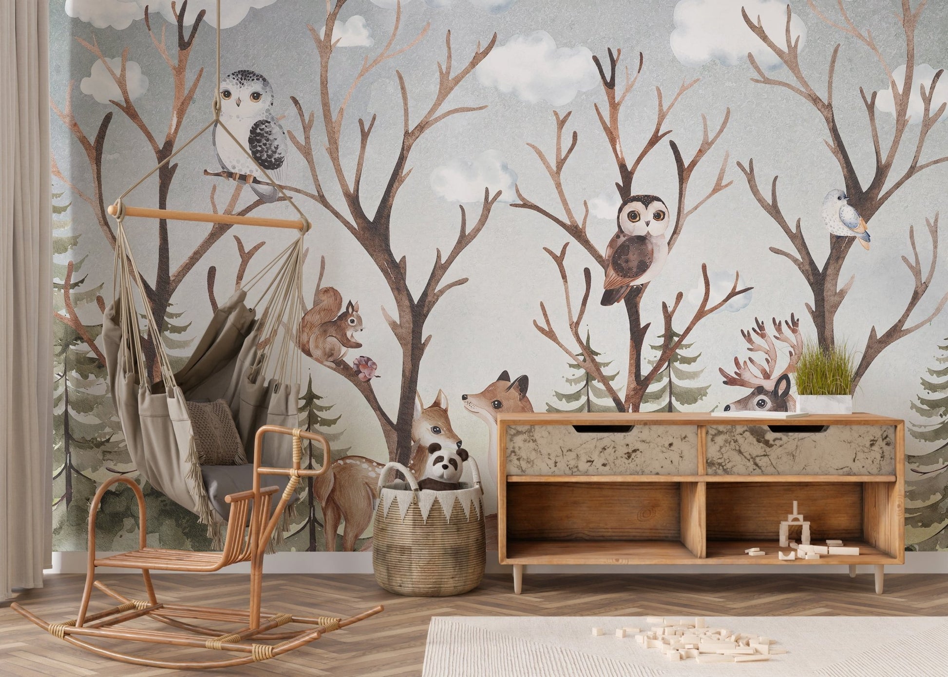 Woodland animal wall mural with owls and trees behind a wooden rocking chair.