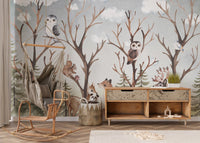 Woodland animal wall mural with owls and trees behind a wooden rocking chair.