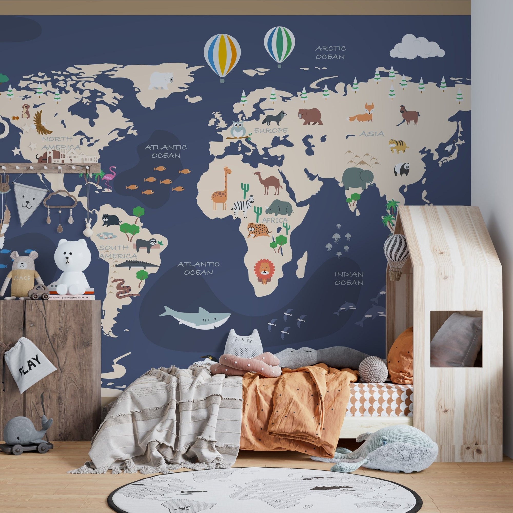 Animated World map wall mural with animals in a kids bedroom featuring a wooden house bed.