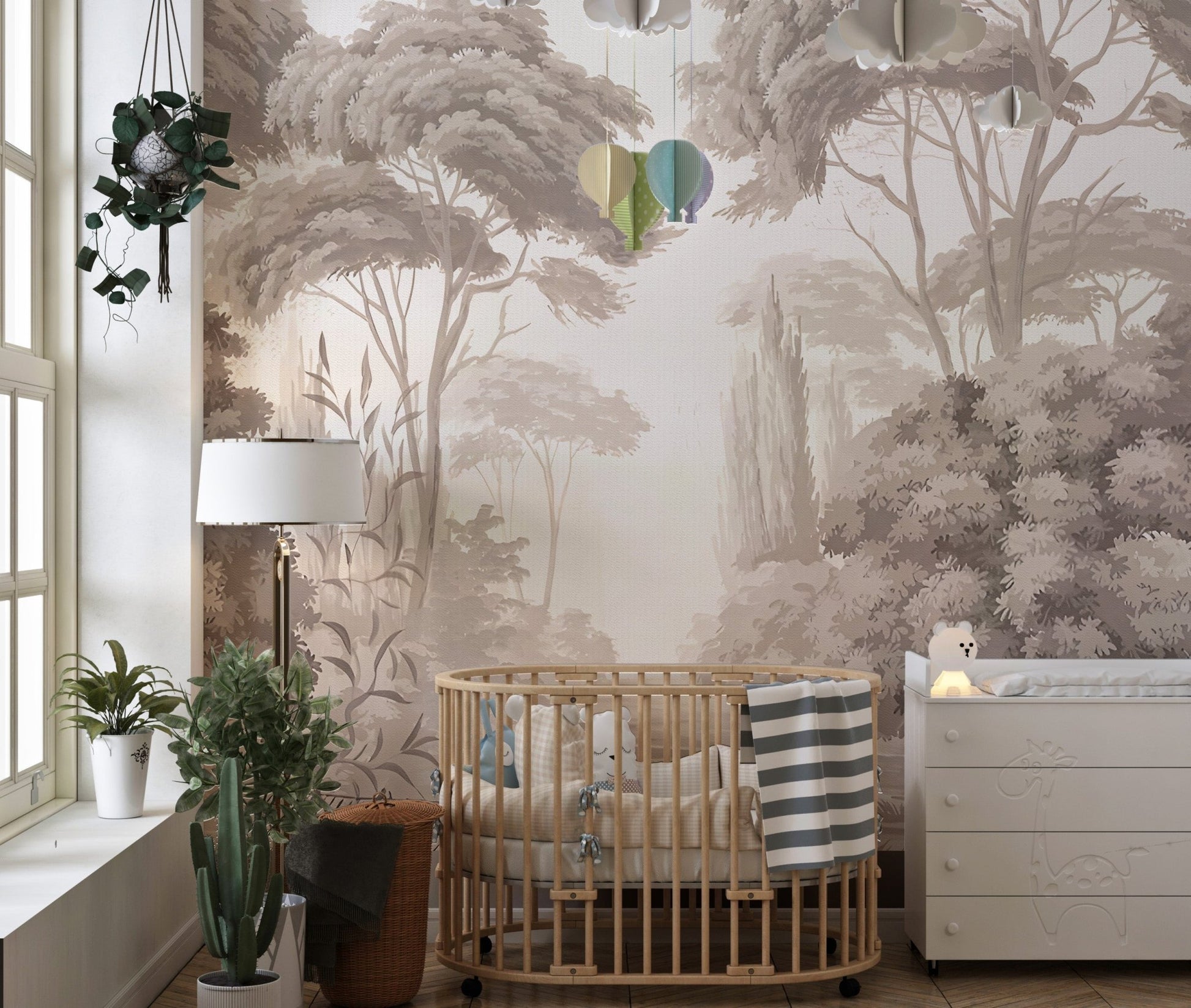 Sepia toned forest wall mural in a nursery with a wooden crib and plants.


