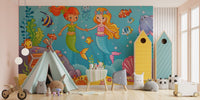 Cartoon mermaid wall mural with orange and yellow fish in a bright playroom.