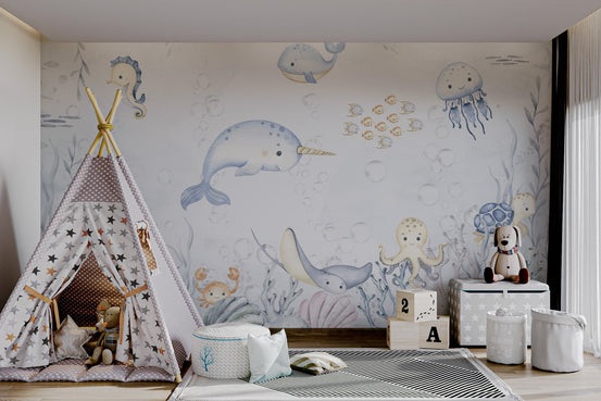 Light blue narwhal with golden horn aquatic animals wall mural in playroom.
