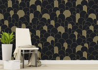 Black and gold Art Deco wallpaper in a living area with a chair and plant.