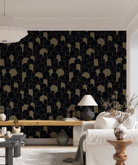 Modern black and gold wallpaper in a bright living space with a wooden desk.