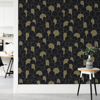 Arched pattern wallpaper behind a small side table and white plant pot.