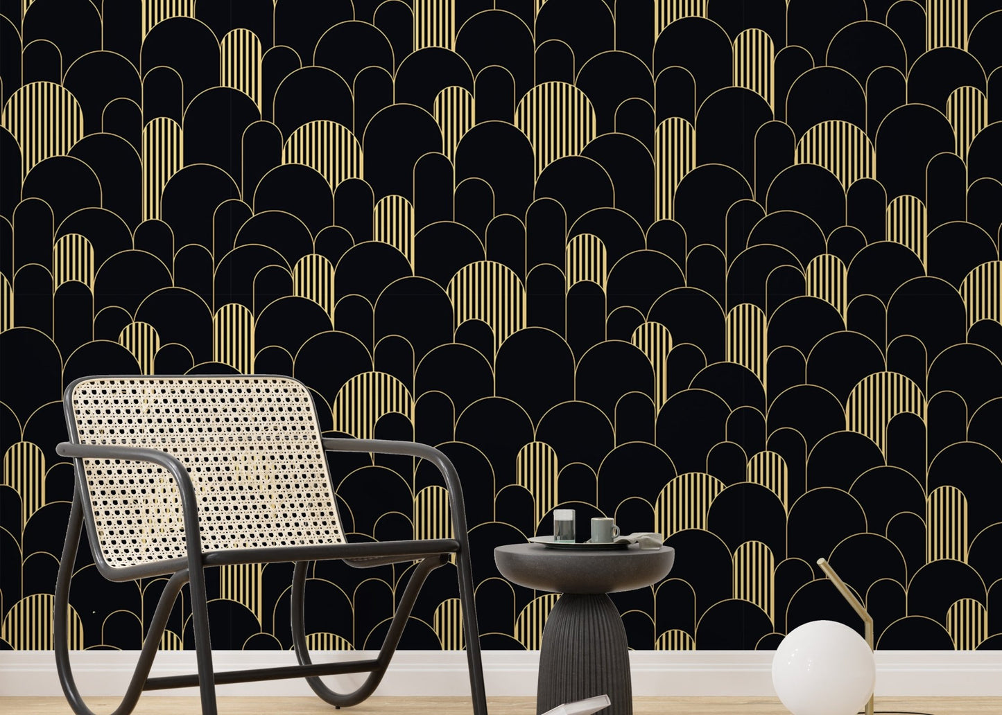Black and gold Art Deco wallpaper in a sitting room with a grey chair and side table.