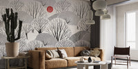 Scenic black and white forest wall mural with grey mountains in a living room.