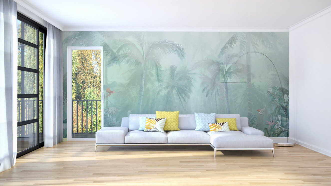 Mint green tropical forest wall mural in a large living room with a white sofa.