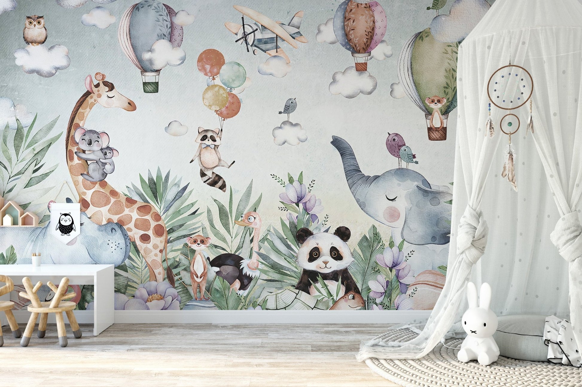 Playroom corner displaying a light blue wildlife and nature wall mural.