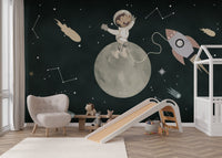 Cartoon monkey astronaut on a cratered moon wall mural for nursery.