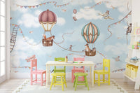 Play area with colorful chairs and a sky blue wall mural with flying animals.