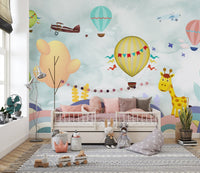 Pastel colored wall mural with hot air balloons and clouds in a bright kids room.