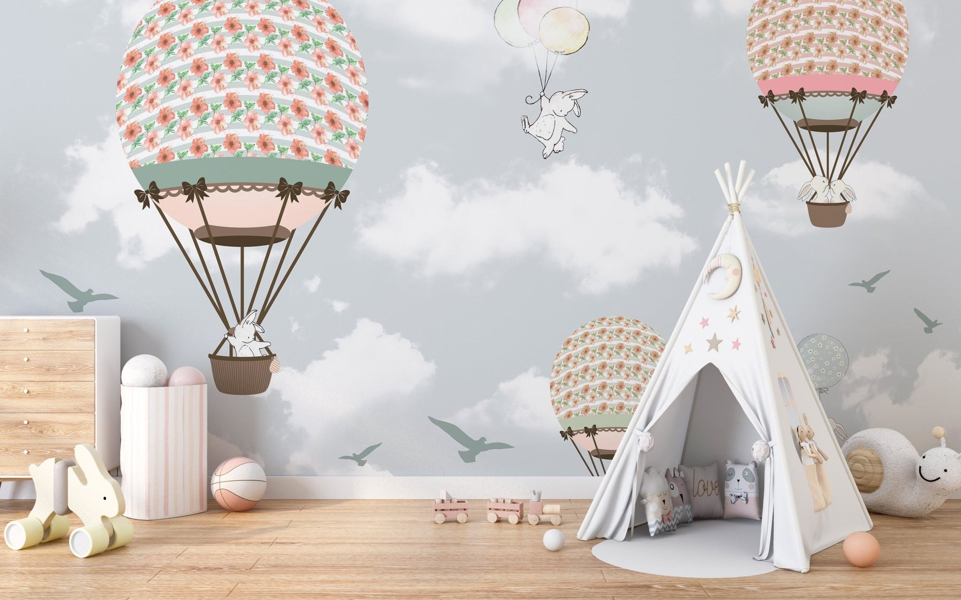 Pastel wildlife wallpaper mural in a nursery featuring a white play teepee.