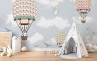 Pastel wildlife wallpaper mural in a nursery featuring a white play teepee.