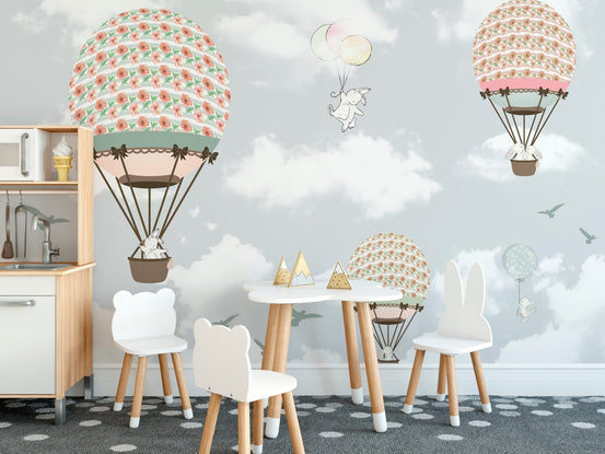 Kids playroom with hot air balloon wall mural and small wooden table set.