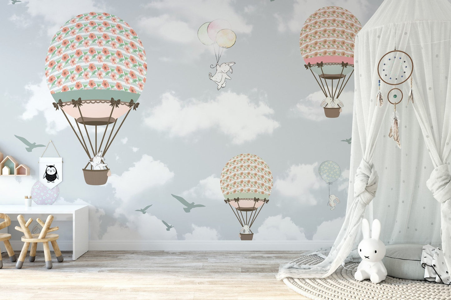 Interactive play zone with a light blue hot air balloon wall mural theme.