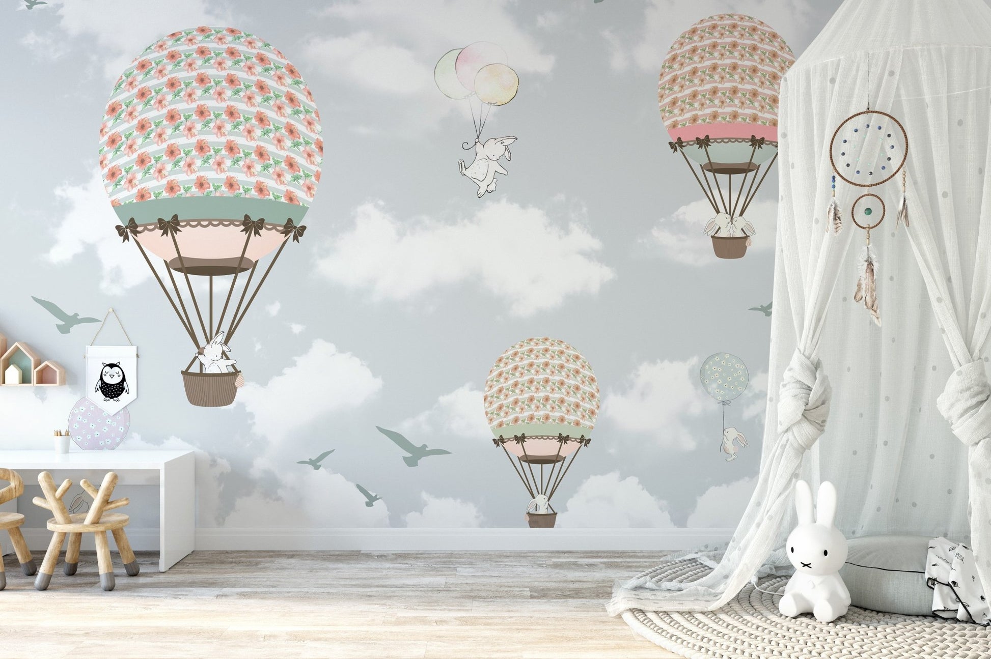 Interactive play zone with a light blue hot air balloon wall mural theme.