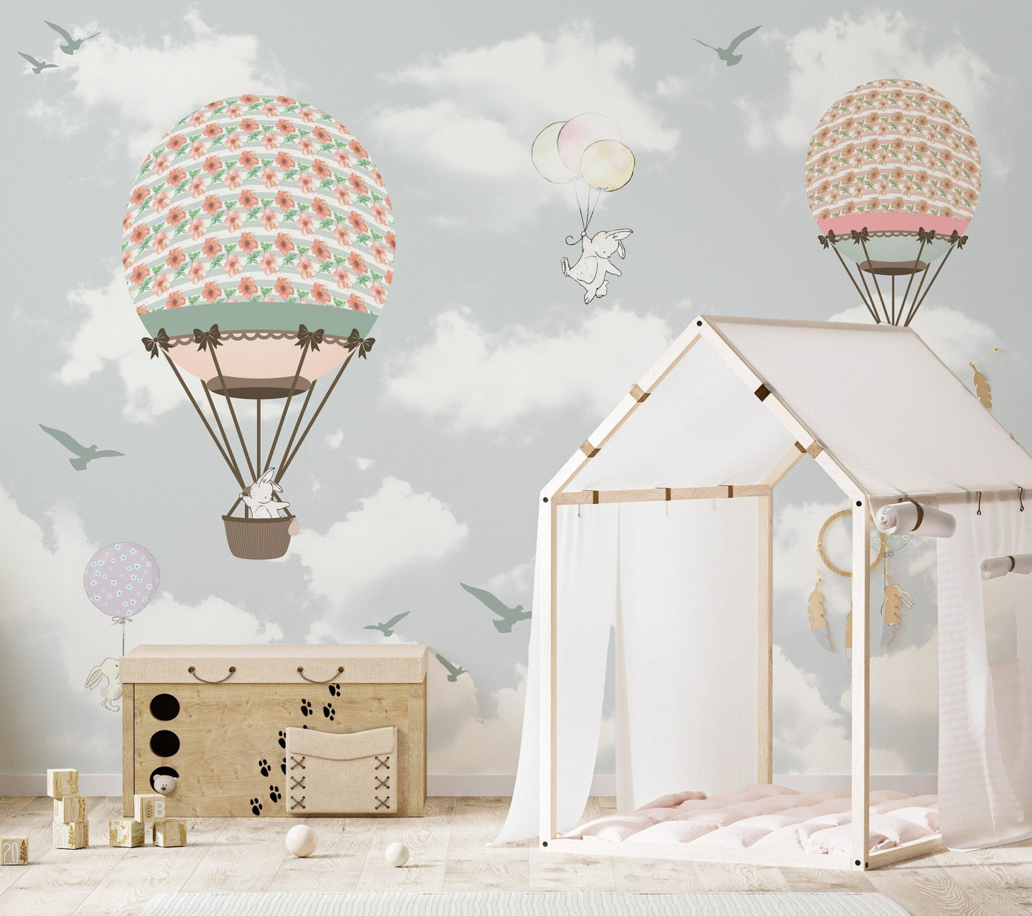 Hot air balloon wonderland wall mural behind a wooden house-shaped bed frame for kids.