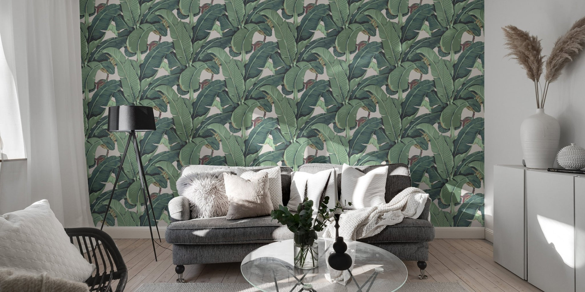 Large green leaf wall mural in a modern living room with a grey sofa.