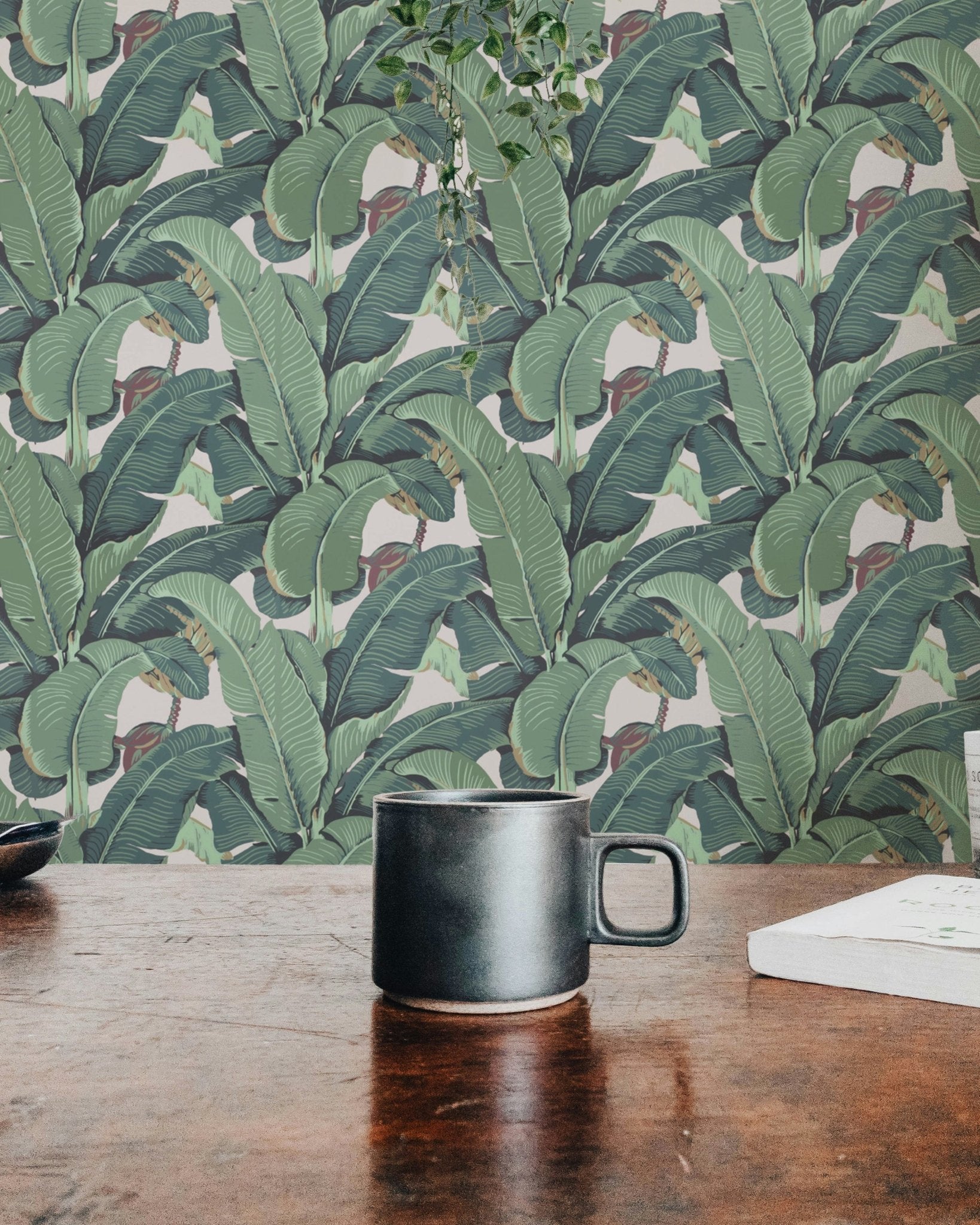 Banana Leaf Tropical Wall mural on a wooden table with a black mug.