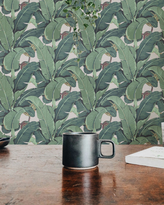 Banana Leaf Tropical Wall mural on a wooden table with a black mug.