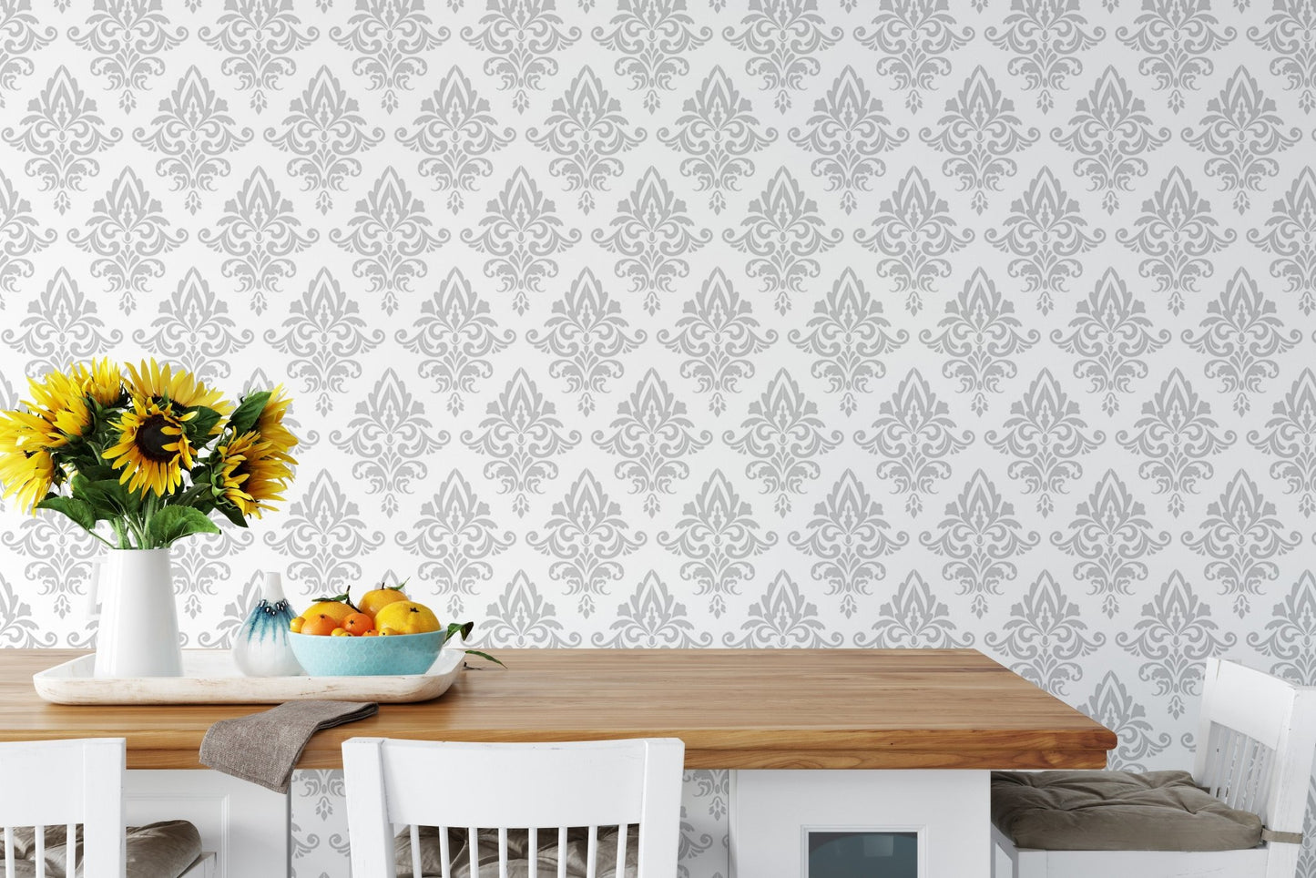 Gray and white damask wallpaper in a dining area with a wooden table.
