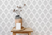 Neutral damask wallpaper used as a backdrop for wooden shelving.