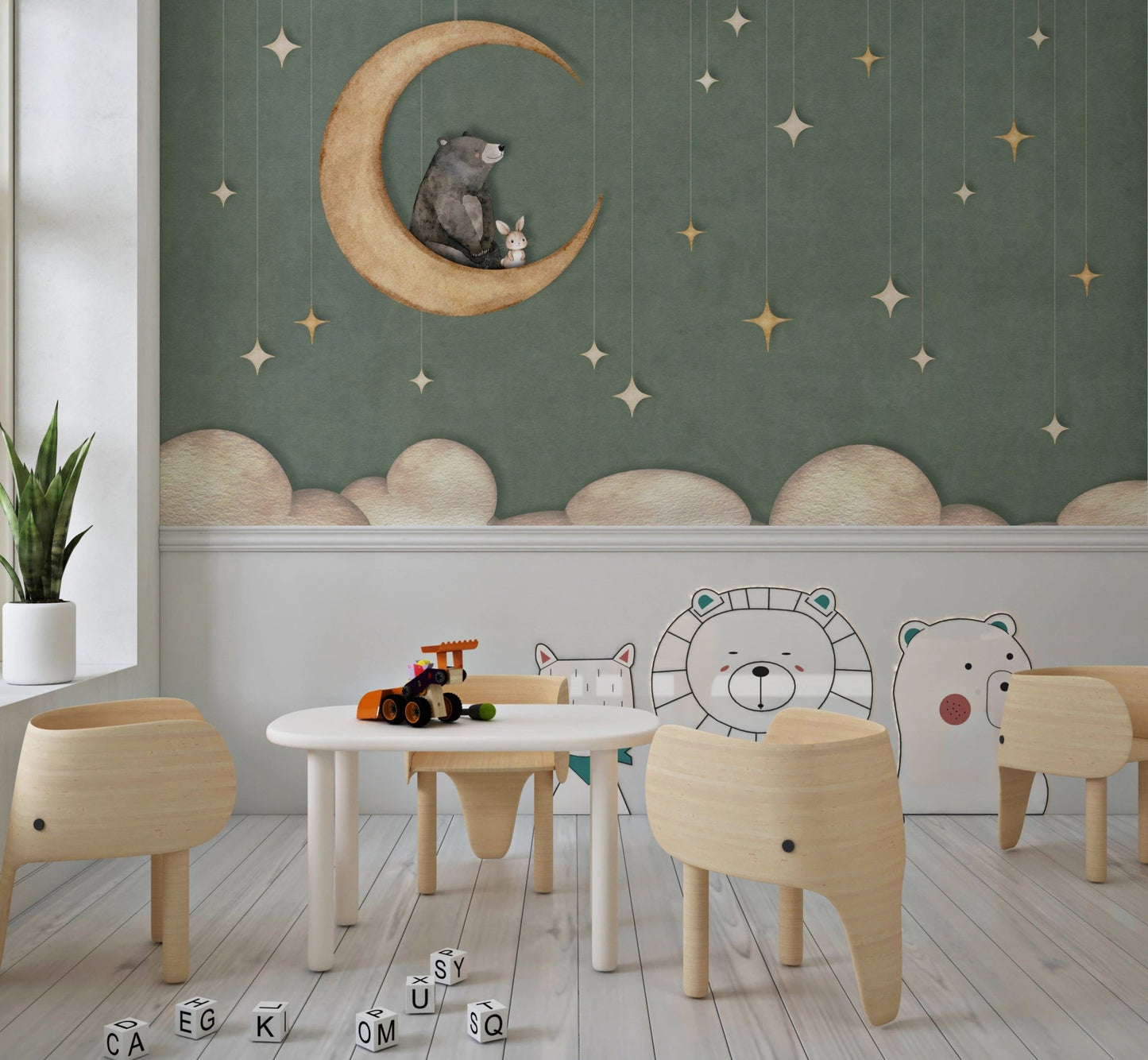 Nursery play area with white furniture and a green moon theme wall mural.